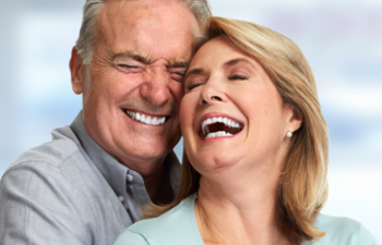 An older man and woman laughing together.