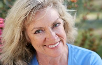 A smiling woman in a blue shirt.