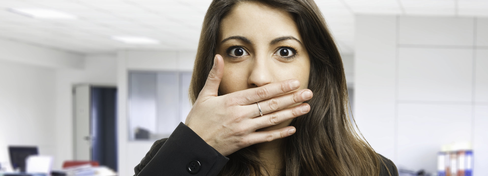 young woman covering her mouth with a hand due to halitosis