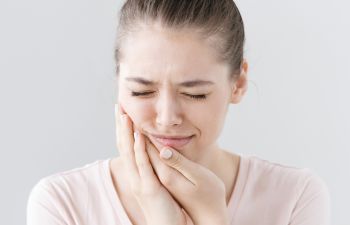 A woman with a toothache holding her hand on her cheek