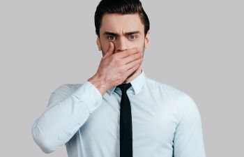 A man covering his mouth with his hand.