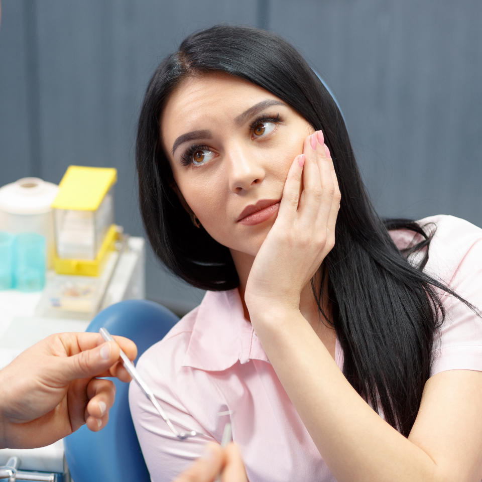 An emergency dentist consulting young woman with dental pain