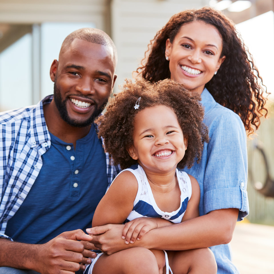 smiling african-american man and woman with their daughter