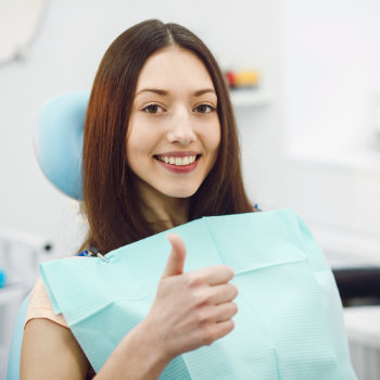 Girl showing thumbs up in the dentist chair