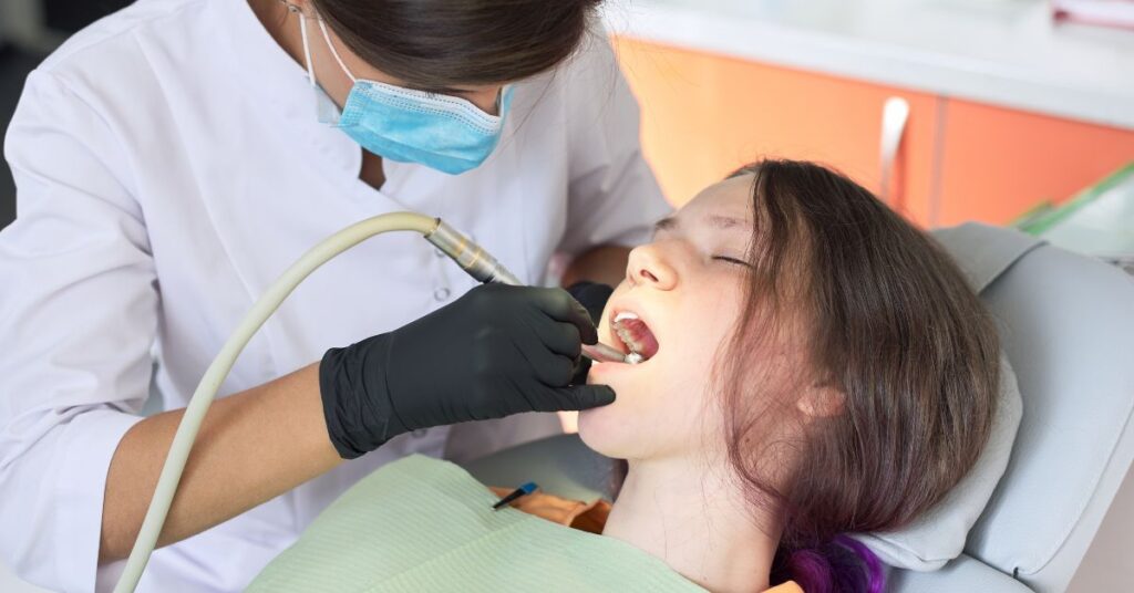 Dental professional cleaning a patient's teeth to remove plaque and prevent gum disease.